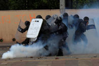 <p>Military policemen react to a gas canister thrown back by a supporter of Salvador Nasralla, presidential candidate for the Opposition Alliance Against the Dictatorship, during a protest caused by the delayed vote count for the presidential election in Tegucigalpa, Honduras, Nov. 30, 2017. (Photo: Jorge Cabrera/Reuters) </p>