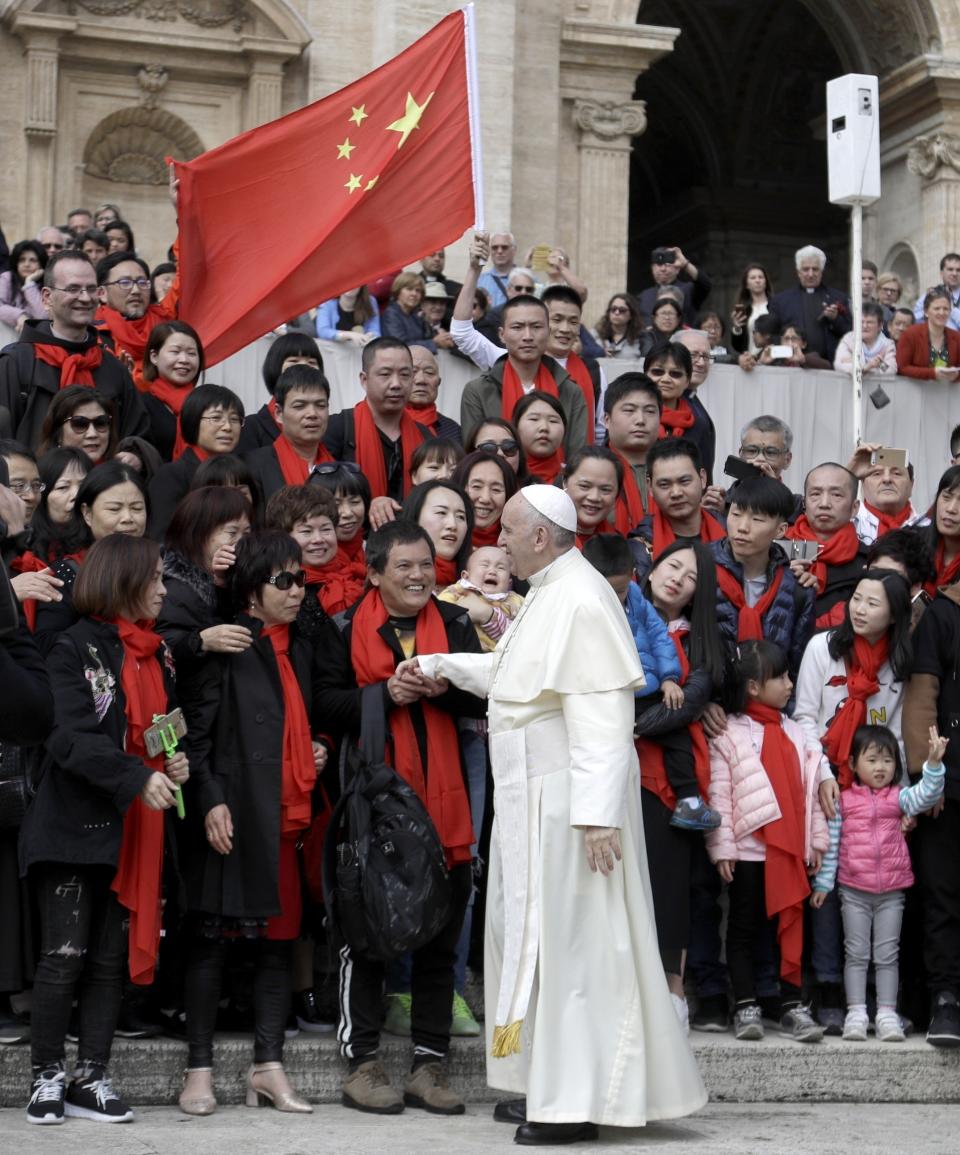 FILE - In this April 18, 2018 file photo, Pope Francis meets a group of faithful from China at the end of his weekly general audience in St. Peter's Square, at the Vatican. The Vatican on Tuesday, Sept. 29, 2020, answered its critics and justified its decision to pursue an extension of an agreement with China over bishop nominations, acknowledging difficulties but insisting that limited, positive results had been achieved.(AP Photo/Gregorio Borgia, file)