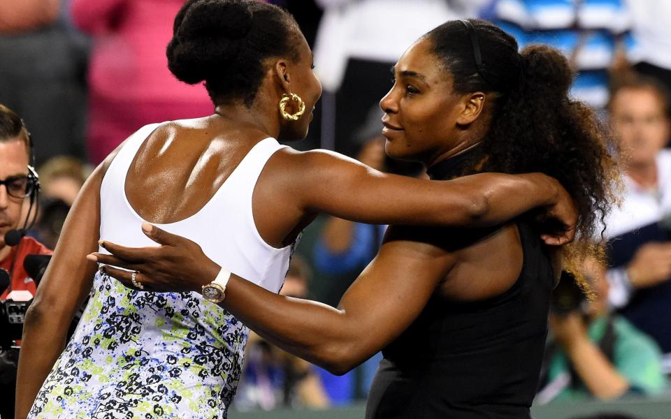 Venus Williams and Serena Williams hug after their third round match - USA TODAY Sports