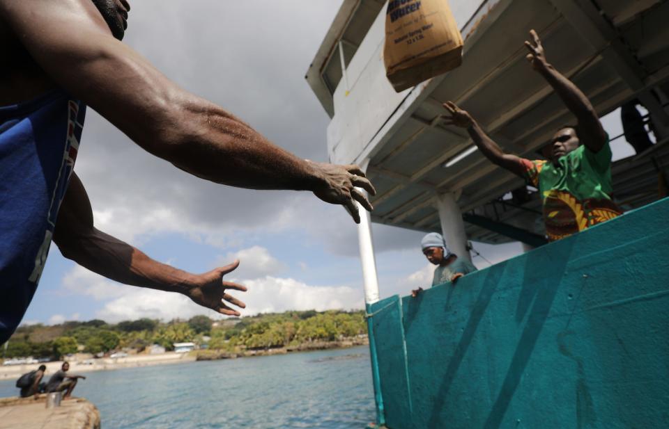 Goods are tossed ashore from a cargo ferry on December 04, 2019 in Tanna, Vanuatu.