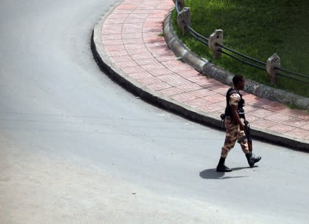 An armed security officer roams on an empty street during a clash between a Sidama youth and securities after they declared their own region in Hawassa