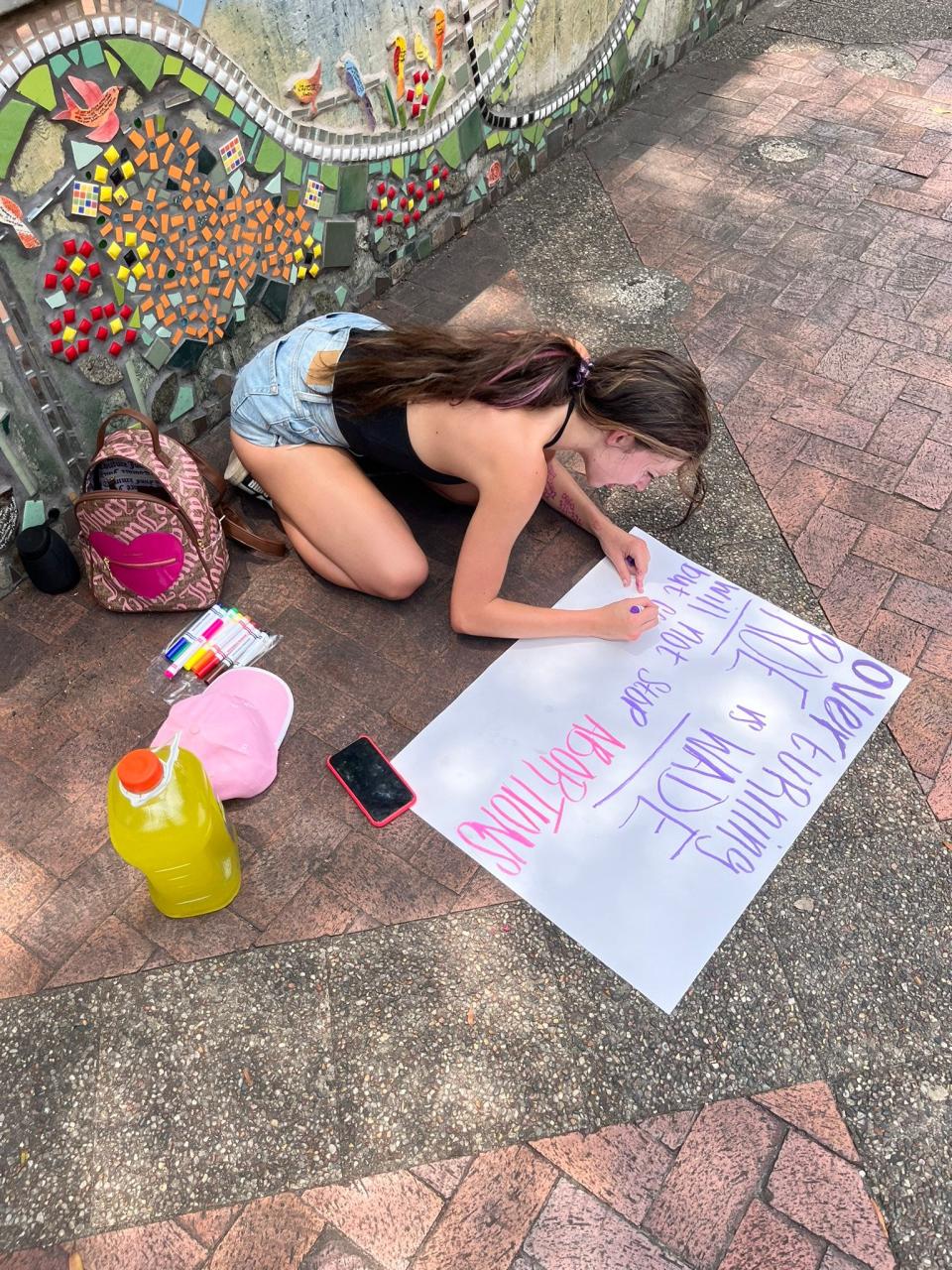 Shyanne, 20, works on her poster board protesting the overturning of Roe v. Wade