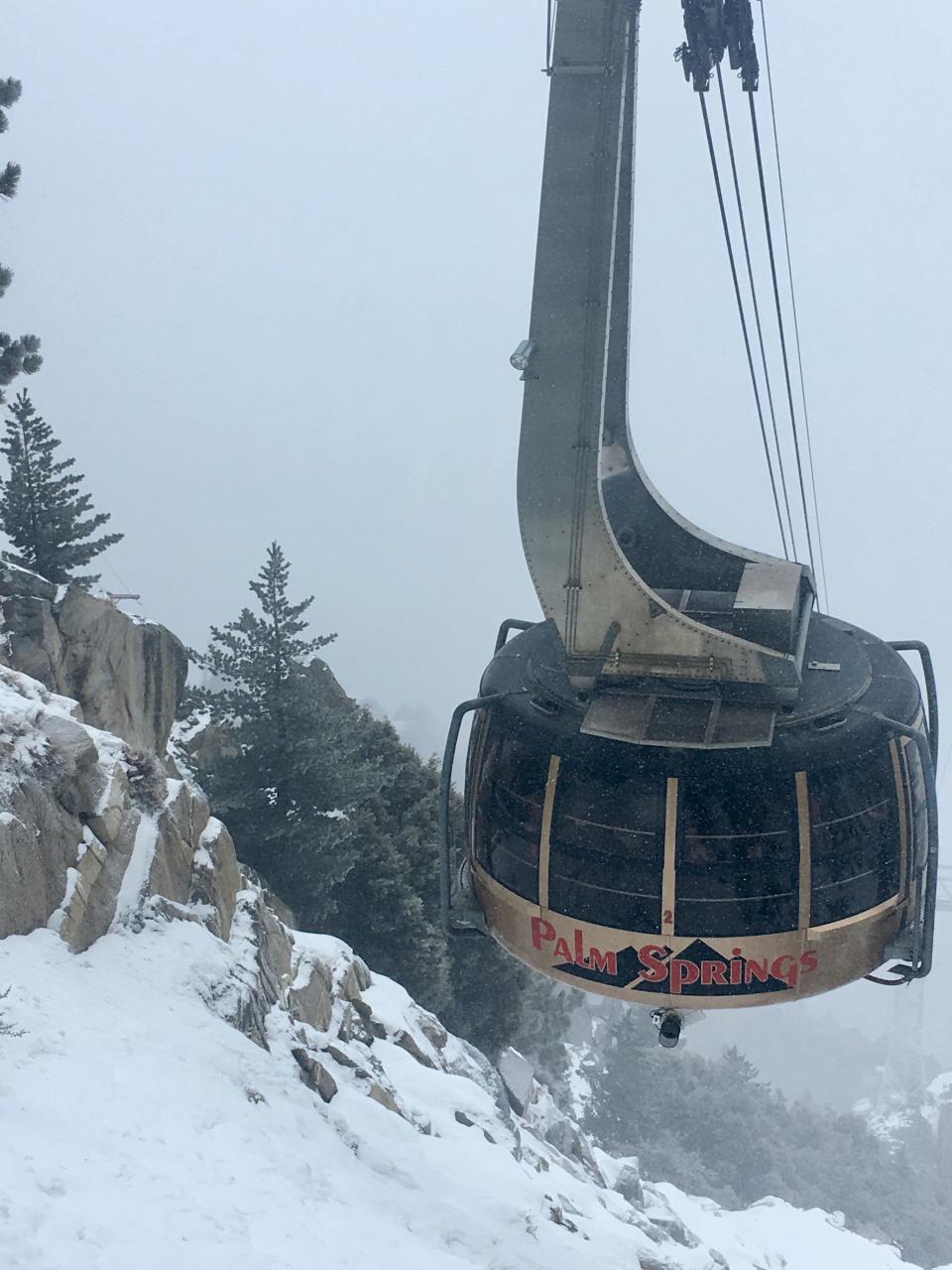 With an accumulation of snow int he background on Mount San Jacinto on Christmas morning, the Palm Springs Aerial Tramway brings passengers to their destination. Some 2 inches of snow fell on the mountain on Tuesday.