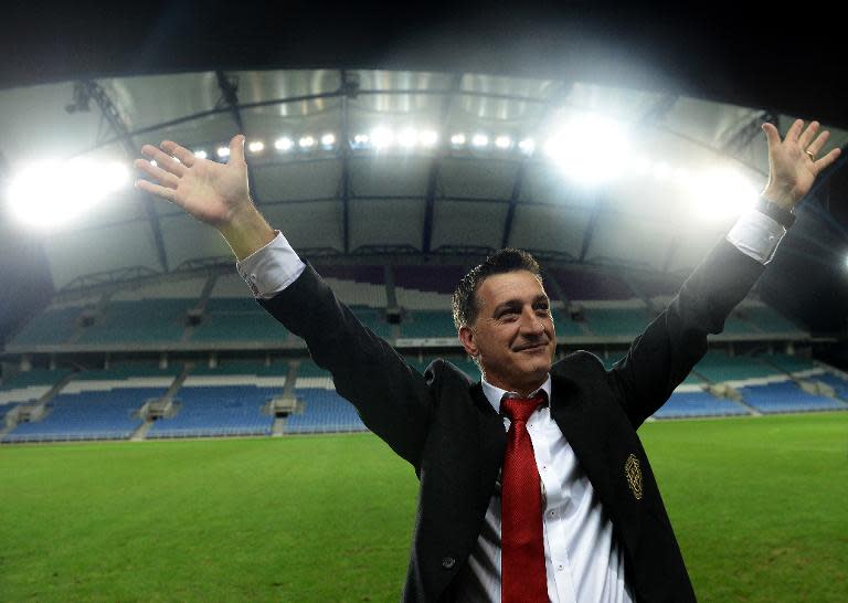 Gibraltar's head coach Allen Bula gestures to supporters at the end of the World Cup 2014 friendly football match against Slovakia at Algarve stadium in Faro on November 19, 2013