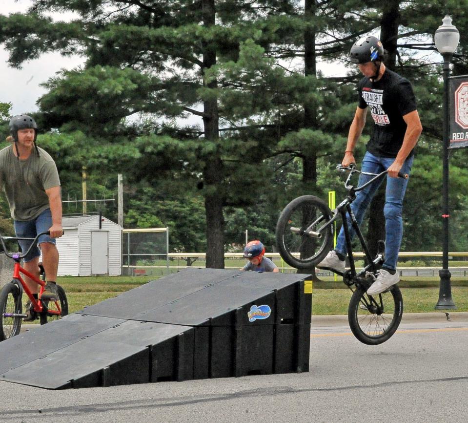 Dylan Alexander lifts his bike off the ground and onto the top of a ramp Saturday during a fundraiser for a skate park in Orrville. The city hopes to open the park in the fall of next year.