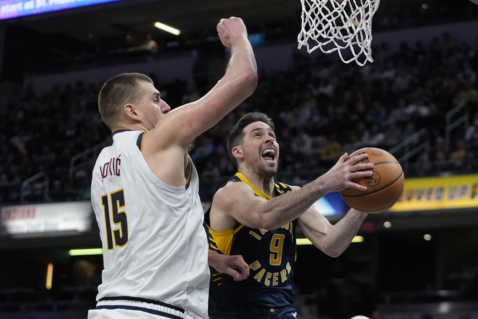 Indiana Pacers' T.J. McConnell (9) shoots against Denver Nuggets' Nikola Jokic (15) during the second half of an NBA basketball game, Tuesday, Jan. 23, 2024, in Indianapolis. (AP Photo/Darron Cummings)
