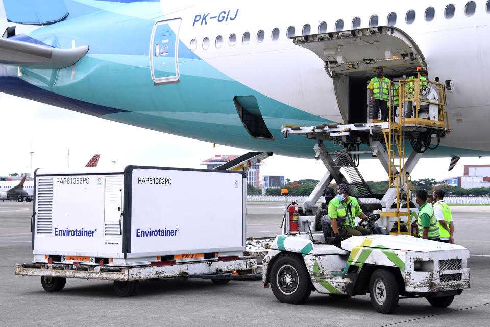In this photo released by the Indonesian Presidential Palace, workers unload a container containing experimental coronavirus vaccines made by the Chinese company Sinovac from the cargo bay of a Garuda Indonesia plane at the Soekarno-Hatta International Airport in Tangerang, Indonesia, Tuesday, Jan, 12, 2021. Indonesia's Food and Drug Authority has green-lighted emergency use of the COVID-19 vaccine produced by China-based Sinovac Biotech Ltd., with vaccinations of high-risk groups expected to start later this week. (Indonesian Presidential Palace via AP)