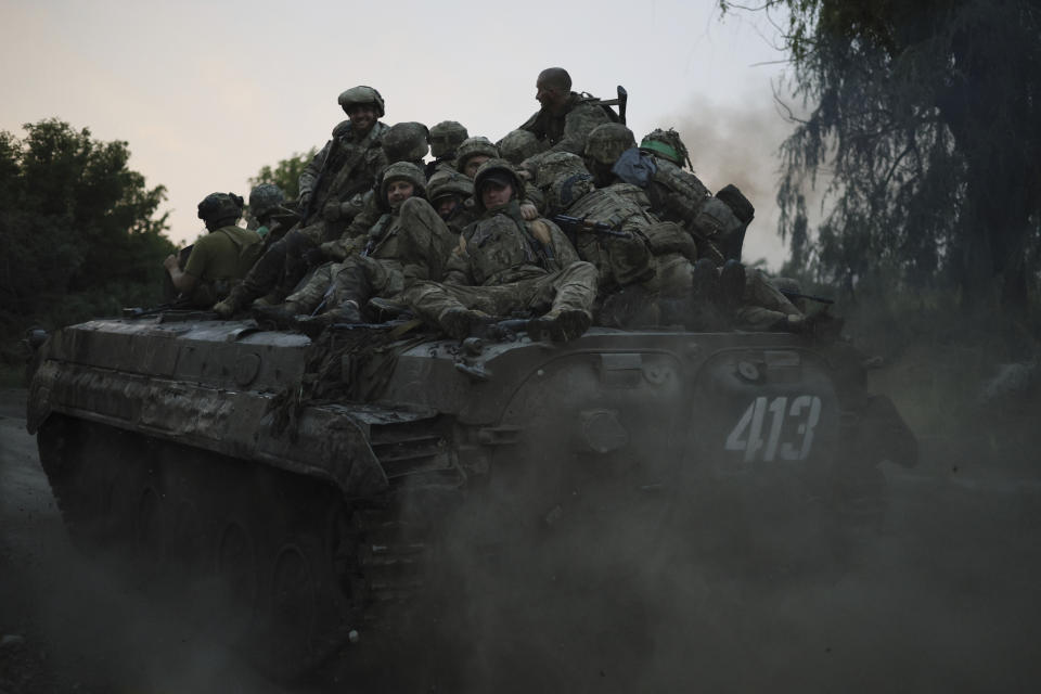 FILE - Ukrainian servicemen ride atop on an APC at the frontline near Bakhmut, Donetsk region, Ukraine, Thursday, June 29, 2023. Ukrainian forces are making steady progress along the northern and southern flanks of Bakhmut, in a semi-encirclement of the wrecked city that Russian forces have been occupying since May. (AP Photo/Alex Babenko, File)