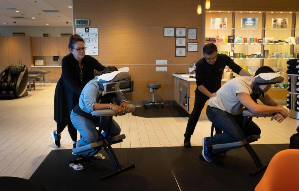 Tania Oropesa, left, massage therapist, and her co-worker massage travelers who came into the XpresSpa by gate D-10 for a massage on Monday, Jan. 29, 2024, at Miami International Airport. “Massage and our massage therapy beds are good for circulation and stress on long trips,” said Assistant Spa Manager Erika O’Connor.