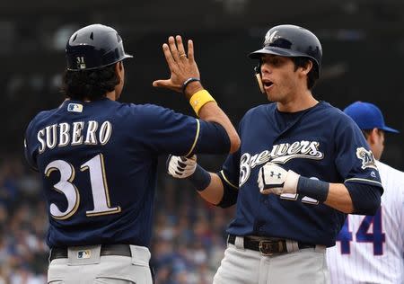 Oct 1, 2018; Chicago, IL, USA; Milwaukee Brewers first base coach Carlos Subero (31) and center fielder Christian Yelich (22) celebrate his RBI single during the third inning against the Chicago Cubs in the National League Central division tiebreaker game at Wrigley Field. Mandatory Credit: Patrick Gorski-USA TODAY Sports