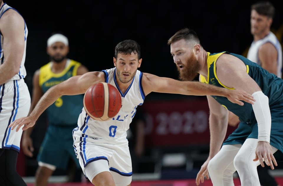 Italy's Marco Spissu (0) and Australia's Aron Baynes (12) chase a loose ball during a men's basketball preliminary round game at the 2020 Summer Olympics, Wednesday, July 28, 2021, in Saitama, Japan. (AP Photo/Eric Gay)