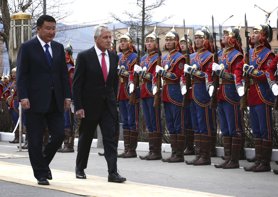 Accompanied by Mongolian Defense Minister Bat-Erdene Dashdemberel, left, U.S. Defense Secretary Chuck Hagel, center, reviews a honor guard during a welcome ceremony at the Mongolian Ministry of Defense Thursday, April 10, 2014 in Ulan Bator, Mongolia. After days of high-profile, pressure-filled meetings, Defense Secretary Chuck Hagel got to horse around a bit during a short stop in Mongolia on Thursday. (AP Photo/Alex Wong, Pool)