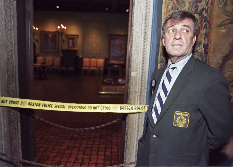 Security guard Paul Daley stands guard at the door of the Dutch Room following a robbery at the Isabella Stewart Gardner Museum in Boston, in this file photo taken March 21,1990. Twelve priceless works of art were stolen from the museum March 18, 1990, including Rembrandt's "The Storm on the Sea of Galilee," which hung in the empty wall space seen in the right background. Twenty-five years have passed since 13 artworks worth $500 million were stolen from Boston's Isabella Stewart Gardner Museum and the costliest art theft in U.S. history remains unsolved. To match Feature USA-BOSTON/GARDNER REUTERS/Jim Bourg/Files (UNITED STATES - Tags: CRIME LAW ENTERTAINMENT)