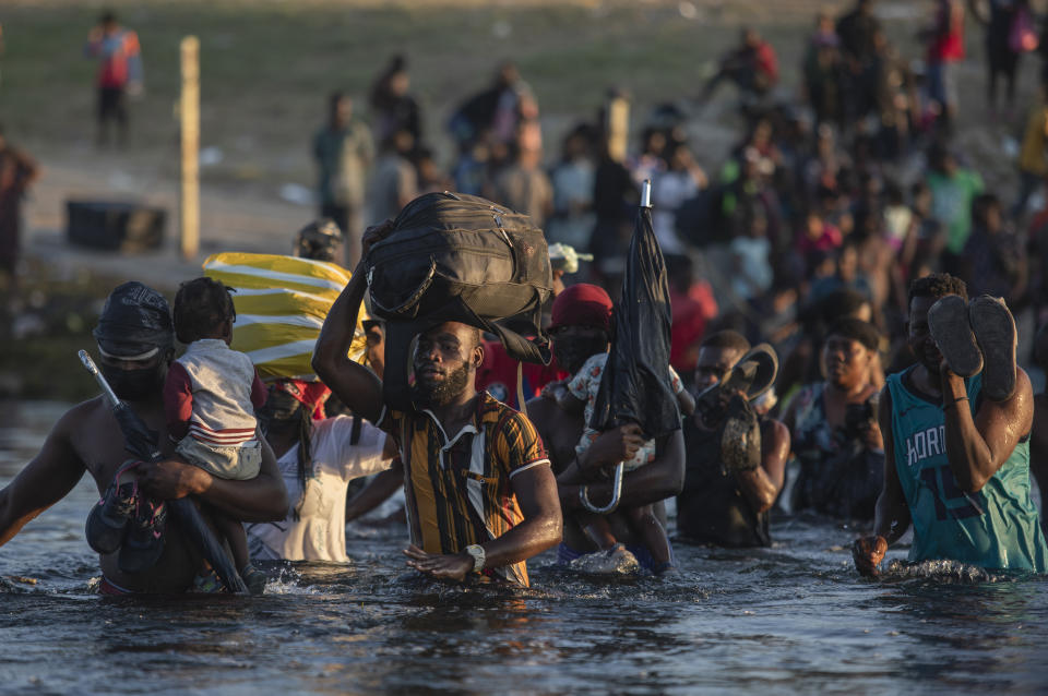 Migrants, many from Haiti, wade across the Rio Grande river from Del Rio, Texas, to return to Ciudad Acuña, Mexico, Monday, Sept. 20, 2021, to avoid deportation from the U.S. The U.S. is flying Haitians camped in a Texas border town back to their homeland and blocking others from crossing the border from Mexico. (AP Photo/Felix Marquez)