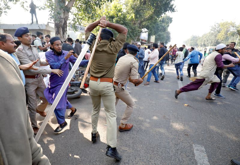 Policemen officers wield sticks against demonstrators during a protest against a new citizenship law, in Ahmedabad