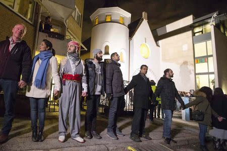 Muslims join hands to form a human shield as they stand outside a synagogue in Oslo February 21, 2015. REUTERS/Hakon Mosvold Larsen/NTB Scanpix