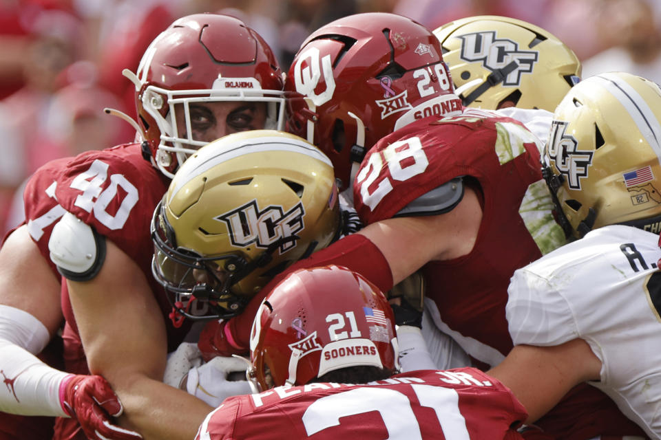 Oklahoma defensive lineman Ethan Downs (40), linebacker Danny Stutsman (28) and defensive back Reggie Pearson (21) stop Central Florida running back RJ Harvey in the second half of an NCAA college football game, Saturday, Oct. 21, 2023, in Norman, Okla. (AP Photo/Nate Billings)