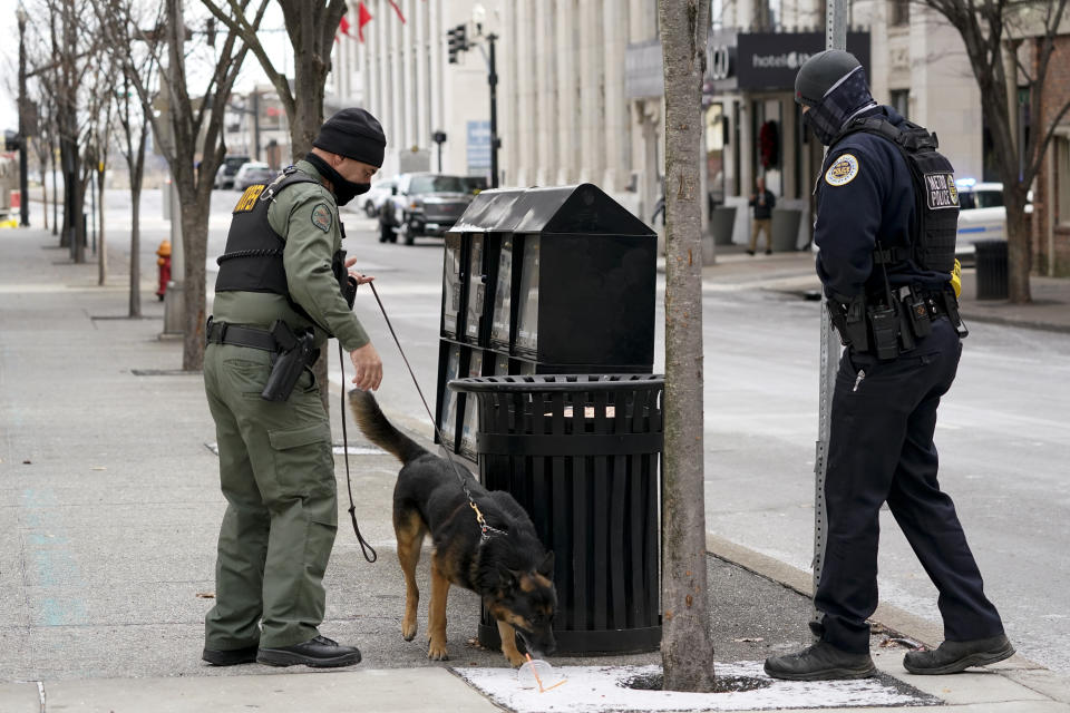 A K-9 team works in the area of an explosion in downtown Nashville, Tenn., Friday, Dec. 25, 2020. Buildings shook in the immediate area and beyond after a loud boom was heard early Christmas morning.(AP Photo/Mark Humphrey)