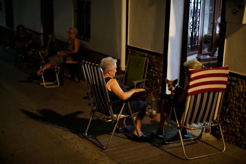 FILE PHOTO: Neighbours try to avoid heat on summer night in Algar