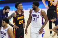 Atlanta Hawks' John Collins, left, and Philadelphia 76ers' Joel Embiid talk during the first half of Game 7 in a second-round NBA basketball playoff series, Sunday, June 20, 2021, in Philadelphia. (AP Photo/Matt Slocum)