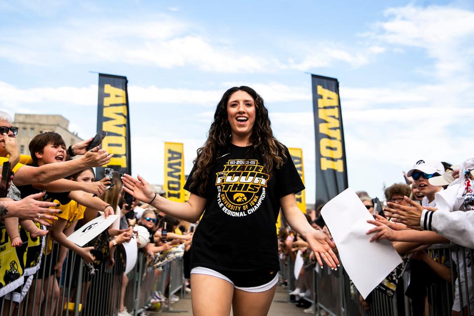 Iowa's McKenna Warnock high-fives fans during a ceremony honoring the women's basketball team, Friday, April 14, 2023, at the Pentacrest in Iowa City, Iowa.