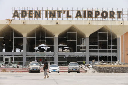 A Southern Resistance fighter walks past a damaged part of the international airport of Yemen's southern port city of Aden July 24, 2015. REUTERS/Faisal Al Nasser