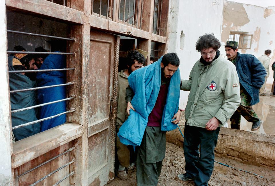 A man leads another man out of a building.