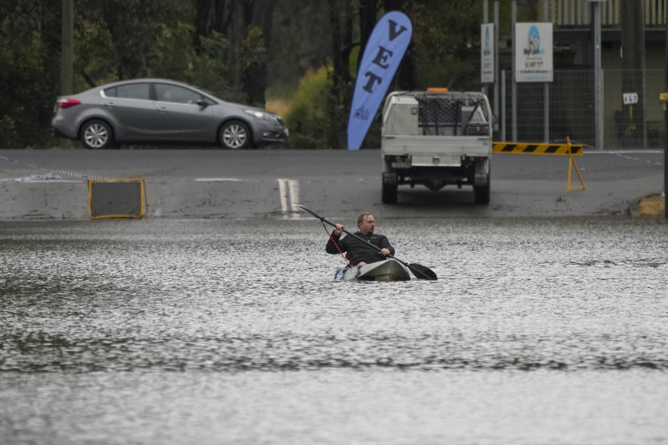 A man paddles his kayak through a flooded street at Windsor on the outskirts of Sydney, Australia, Tuesday, July 5, 2022. Hundreds of homes have been inundated in and around Australia's largest city in a flood emergency that was impacting 50,000 people, officials said Tuesday. (AP Photo/Mark Baker)