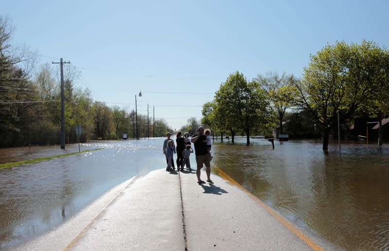 Residents look at a partially submerged street along the Tittabawassee River, after two dam failures submerged parts of Midland, Michigan