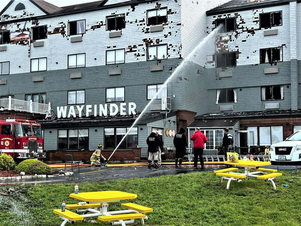 A steady stream of water is trained on the fourth floor of the Wayfinder Hotel in Newport on Tuesday morning as firefighters target remaining hot spots. STORY, PAGE XA