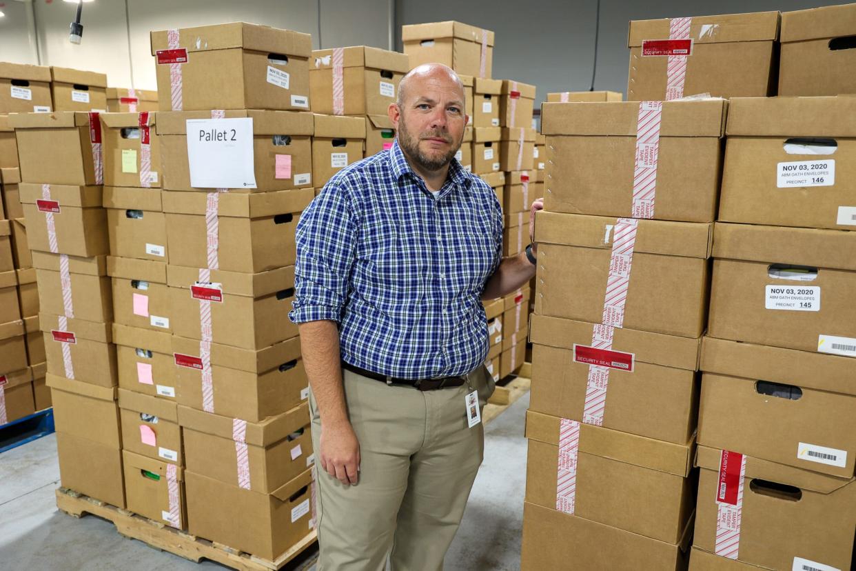Gwinnett County Elections Supervisor Zach Manifold in his office, which is filled with elections documents dating to 2020. Some files have to be retained because of ongoing lawsuits. Manifold says cases of intimidation have made it harder for him to hire poll workers.