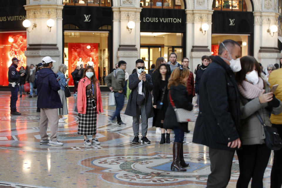 Tourists wearing sanitary masks walk in downtown Milan, Italy, on Sunday. The country has reported Europe's largest number of cases of&nbsp;COVID-19. (Photo: ASSOCIATED PRESS)