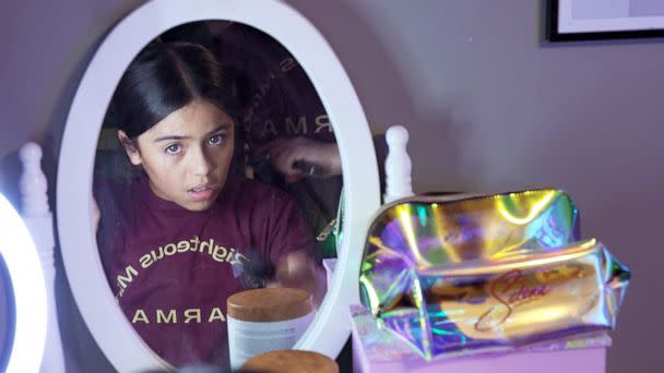 PHOTO: Caitlyne Gonzales gets help from her mom Gladys Gonzales during her bedtime routine on Feb. 25, 2023. (ABC News)