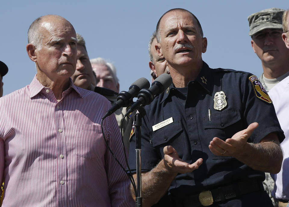 FILE — Then California Gov. Jerry Brown and then California Department of Forestry and Fire Protection Chief Ken Pimlott, right, discuss the wildfire in Lake County during a news conference at the Cowboy Camp Trailhead near Clearlake, Calif., Aug. 6, 2015. Brown has called California's mega fires "the new abnormal" as climate change turns the state warmer and drier. With the help of Pimlott, he convened a group at his rural Colusa County ranch in September 2021, to discuss what could be done to save California's forests. (AP Photo/Jeff Chiu, File)