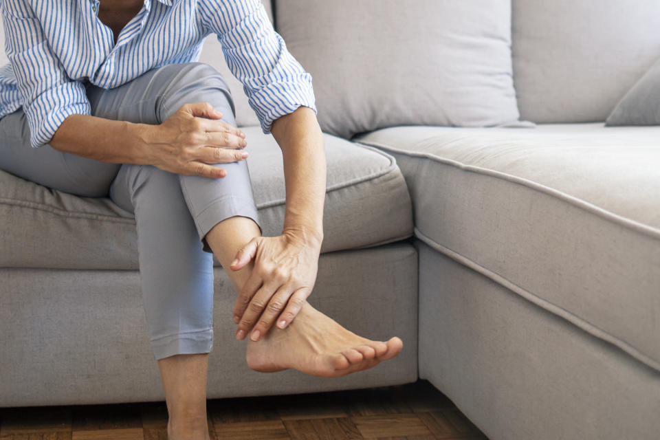 A woman touching her ankle