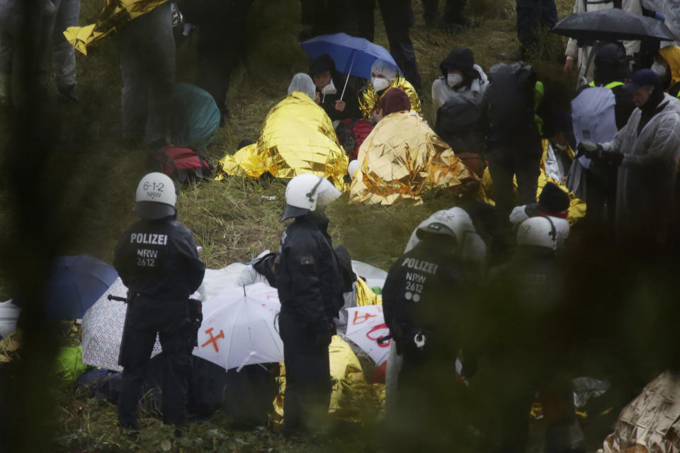 Activists are surrounded by police on the Garzweiler power plant grounds in Grevenbroich, western Germany, Saturday, Sept. 26, 2020. Anti-coal protesters have entered a mine to protest the continued extraction and use of fossil fuels. (David Young/dpa via AP)