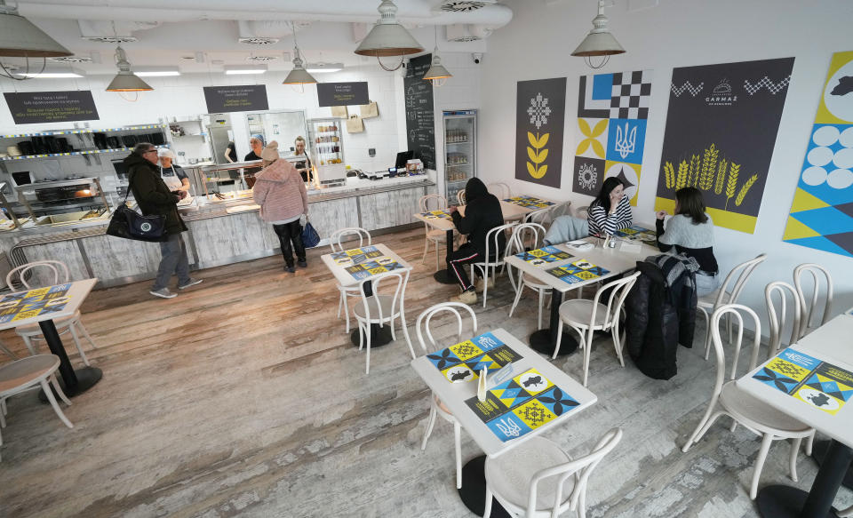 Ukrainian refugee women working at a Ukrainian food bar that a private foundation has opened to offer jobs to the refugees, in Warsaw, Poland, on Friday, April 1, 2022. Having escaped from Russian shelling, Ukrainian refugees are now focused on building new lives — temporarily or permanently. Countries neighboring their homeland, like Poland and Romania, are sparing no effort to help them integrate and feel needed in the new environment.(AP Photo/Czarek Sokolowski)