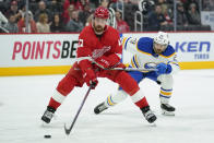 Detroit Red Wings defenseman Filip Hronek (17) protects the puck from Buffalo Sabres center Vinnie Hinostroza (29) in the first period of an NHL hockey game Saturday, Jan. 15, 2022, in Detroit. (AP Photo/Paul Sancya)