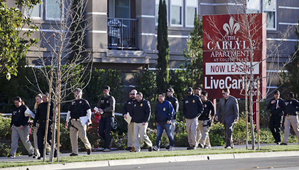 FILE - In this March 3, 2015 file photo, federal agents enter an upscale apartment complex where authorities say a birth tourism business charged pregnant women $50,000 for lodging, food and transportation, in Irvine, Calif. On Thursday, Jan. 31, 2019, authorities announced they have charged 20 people in an unprecedented crackdown on businesses that helped hundreds of Chinese women travel to the United States to give birth to American citizen children. (AP Photo/Jae C. Hong, File)