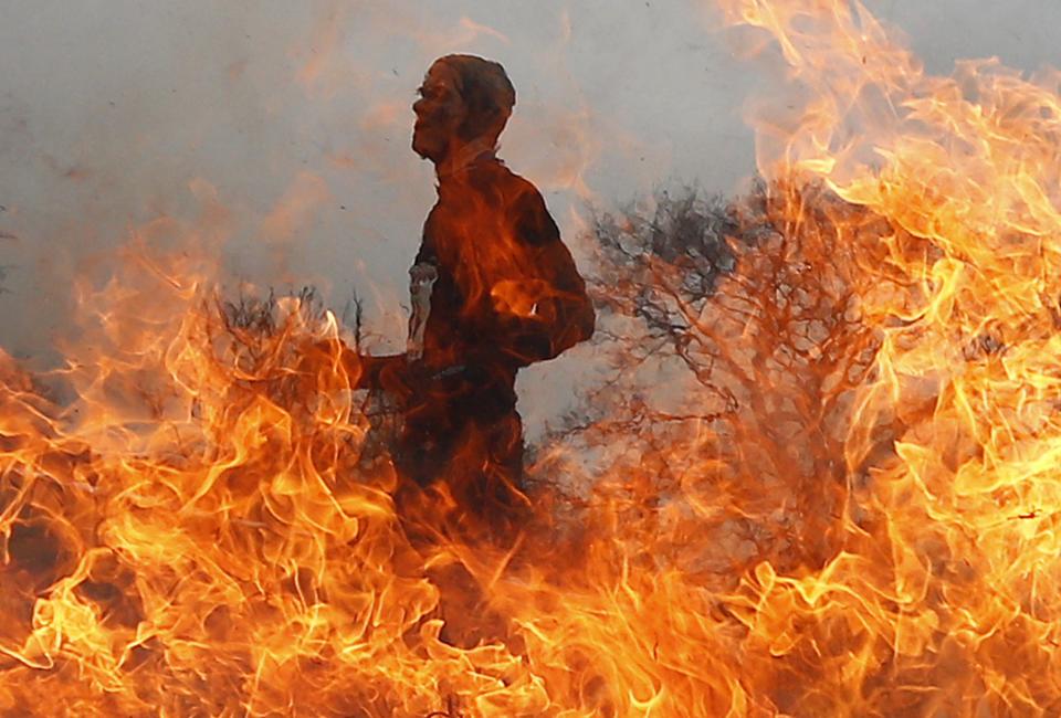 Competitor runs through a burning obstacle during the Tough Guy event in Perton