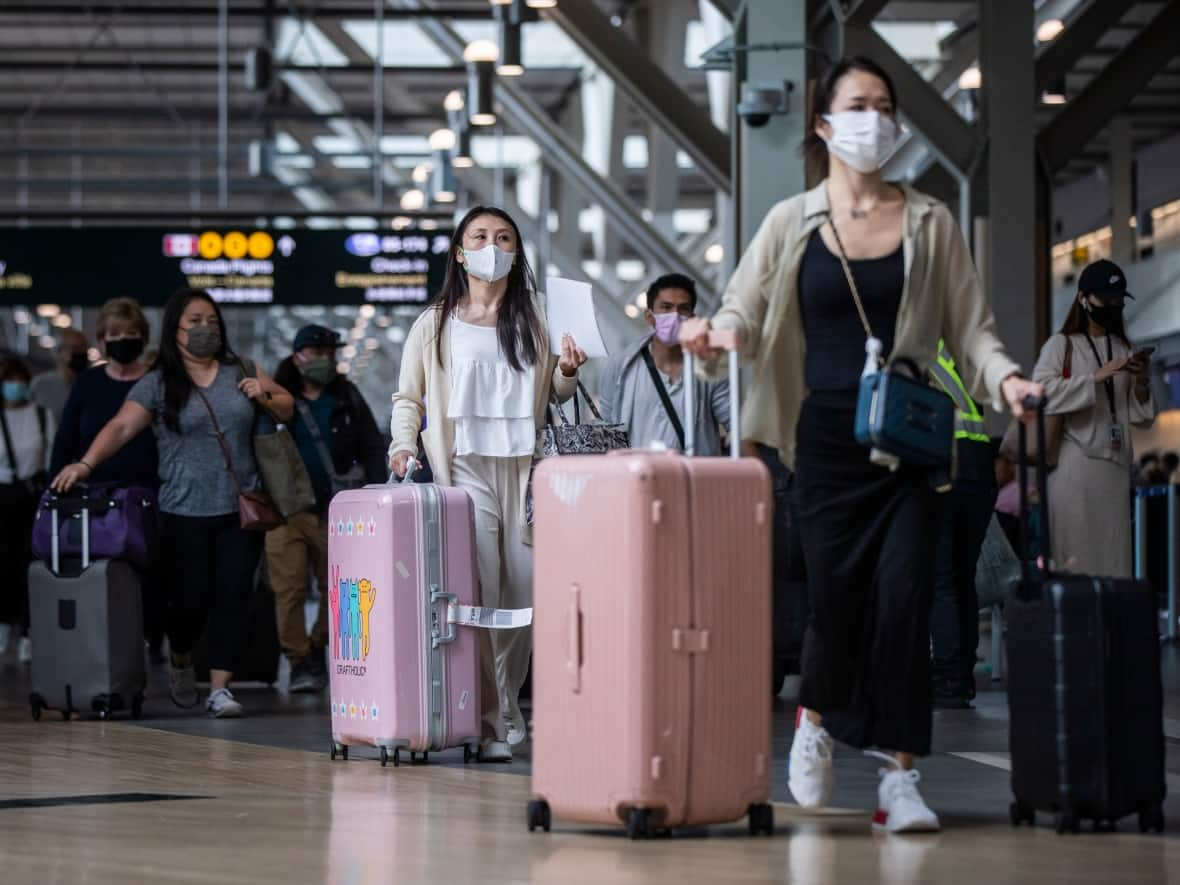 Travellers are pictured at Vancouver International Airport on Sept. 26. A new program from the airport authority will allow U.S.-bound travellers to book a security screening time, helping them to skip the line. (Ben Nelms/CBC - image credit)