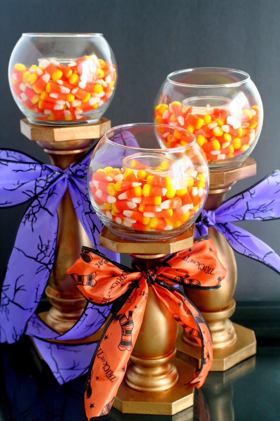 <p>These gilded candlestick holders can corral candles or candy!</p><p><strong>Get the tutorial at <a href="https://jordanseasyentertaining.com/2014/10/halloween-candle-holders.html" rel="nofollow noopener" target="_blank" data-ylk="slk:Jordan's Easy Entertaining;elm:context_link;itc:0;sec:content-canvas" class="link ">Jordan's Easy Entertaining</a>.</strong> </p>