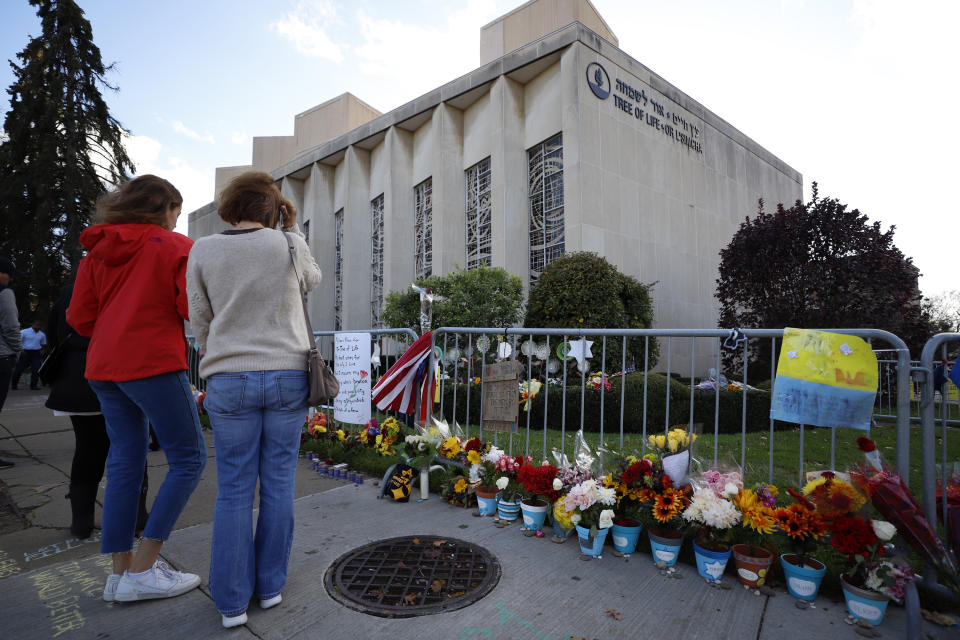 Passersby stop to pay respect outside the Tree of Life synagogue in Pittsburgh on Sunday, Oct. 27, 2019, the first anniversary of the shooting at the synagogue, that killed 11 worshippers. (AP Photo/Gene J. Puskar)