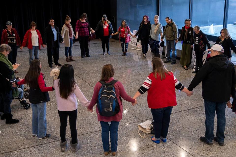 Protesters form a prayer circle in the lobby at the Sacramento County offices after disrupting a Board of Supervisors meeting over proposed COVID penalties on Tuesday, Dec. 8, 2020, in Sacramento.