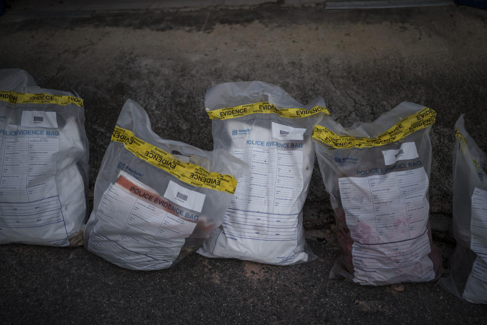 Police evidence bags containing clothing and other items found on a Mauritanian boat are laid out at the Scarborough police station in Tobago, Trinidad and Tobago, Friday, Jan. 21, 2022. The boat was found by local fishermen drifting nearby on May 28, 2021 with 14 bodies and other skeletal remains inside. An AP investigation has found that the boat had departed the port town of Nouadhibou in Mauritania, Africa more than four months earlier with 43 migrants. (AP Photo/Felipe Dana)