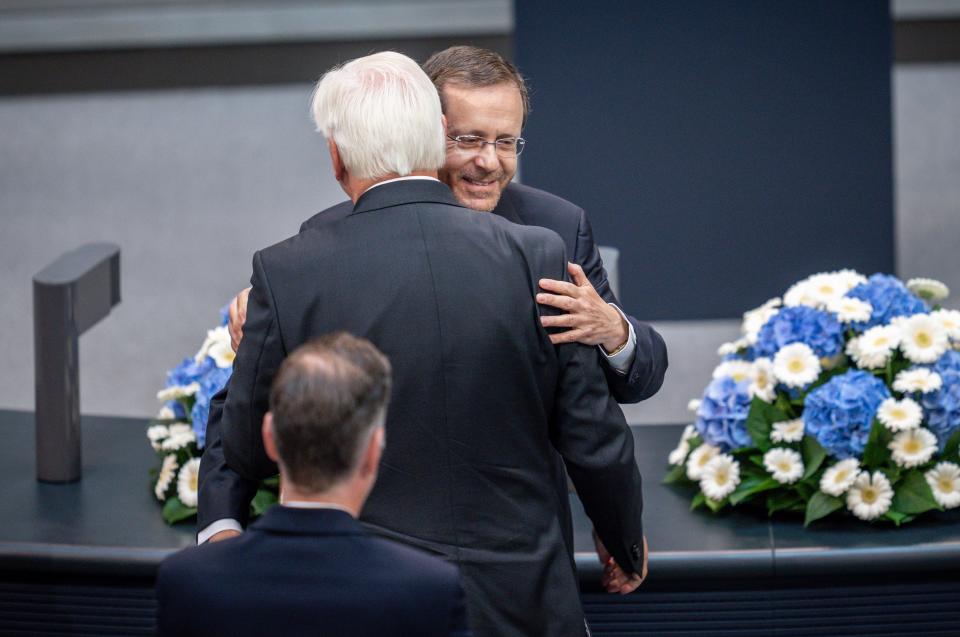 Israeli President Isaac Herzog, right, embarances German President Frank-Walter Steinmeier as he receives standing ovations after his speech at the German parliament Bundestag at the Reichstag building in Berlin, Germany, Tuesday, Sept. 6, 2022. (Michael Kappeler/dpa via AP)