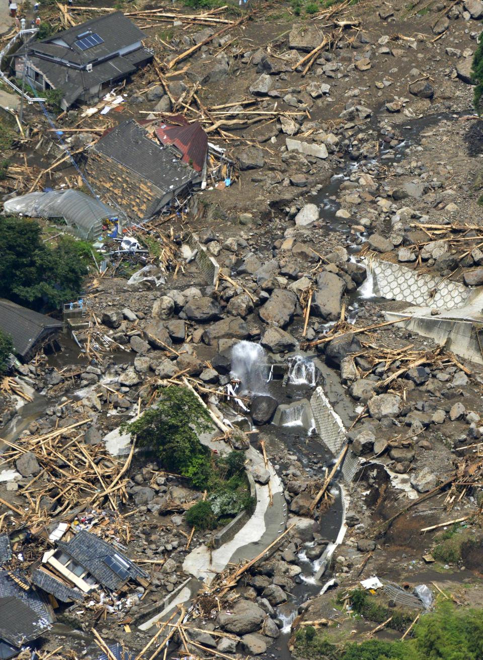 Houses are buried in a landslide in Aso, Kumamoto Prefecture, Japan, Sunday, July 15, 2012. Heavy rain triggered flash floods and mudslides in southern Japan this week, killing over two dozens of people. (AP Photo/Kyodo News) JAPAN OUT, MANDATORY CREDIT, NO LICENSING IN JAPAN, CHINA, HONG KONG, SOUTH KOREA AND FRANCE