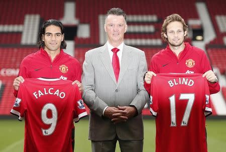New Manchester United signings Radamel Falcao (L) and Daley Blind (R) pose with manager Louis Van Gaal during a photocall at Old Trafford in Manchester, northern England September 11, 2014. REUTERS/Phil Noble