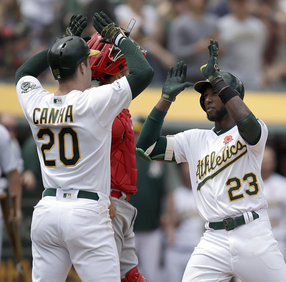 Oakland Athletics' Jurickson Profar, right, celebrates with Mark Canha (20) after hitting a two-run home run off Los Angeles Angels' Trevor Cahill in the fourth inning of a baseball game Monday, May 27, 2019, in Oakland, Calif. (AP Photo/Ben Margot)