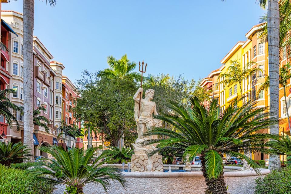 Colorful multicolored Bayfront condos buildings with water fountain and statue of Poseidon Greek god of water in Florida